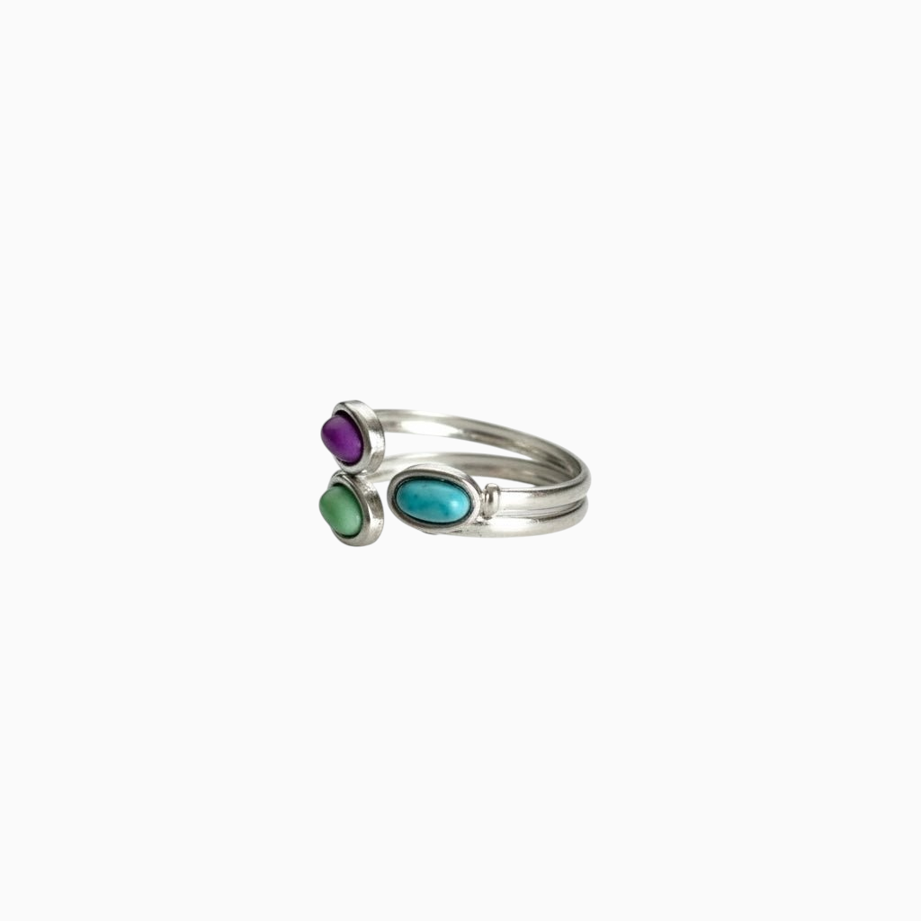 Anel GRINE ajustável em aço inoxidável com três pedras ovais coloridas em tons de roxo, verde e azul.