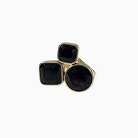 Anel GRINE em aço inoxidável dourado com três pedras pretas lapidadas em design sofisticado e ajustável.