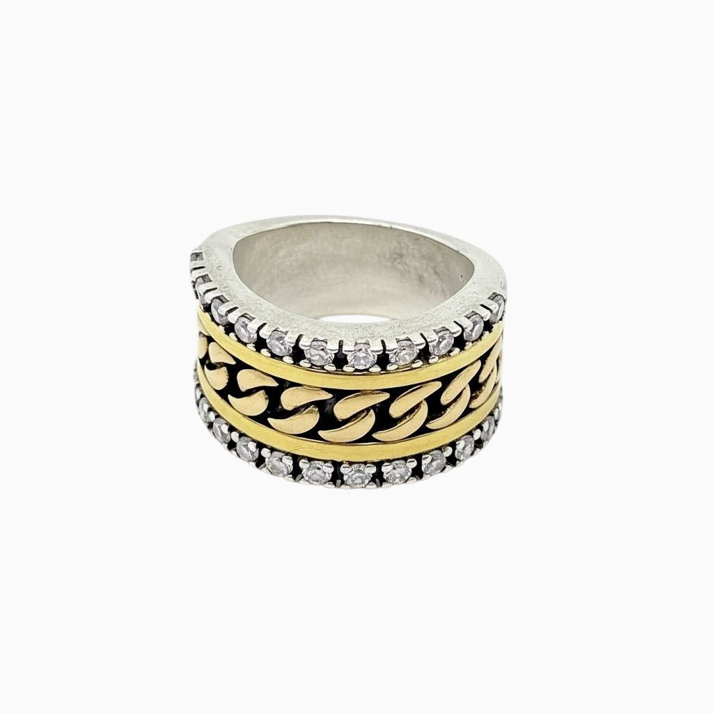 Anel GRINE com design de corrente prateada e dourada, decorado com zircónias brilhantes em fundo branco.