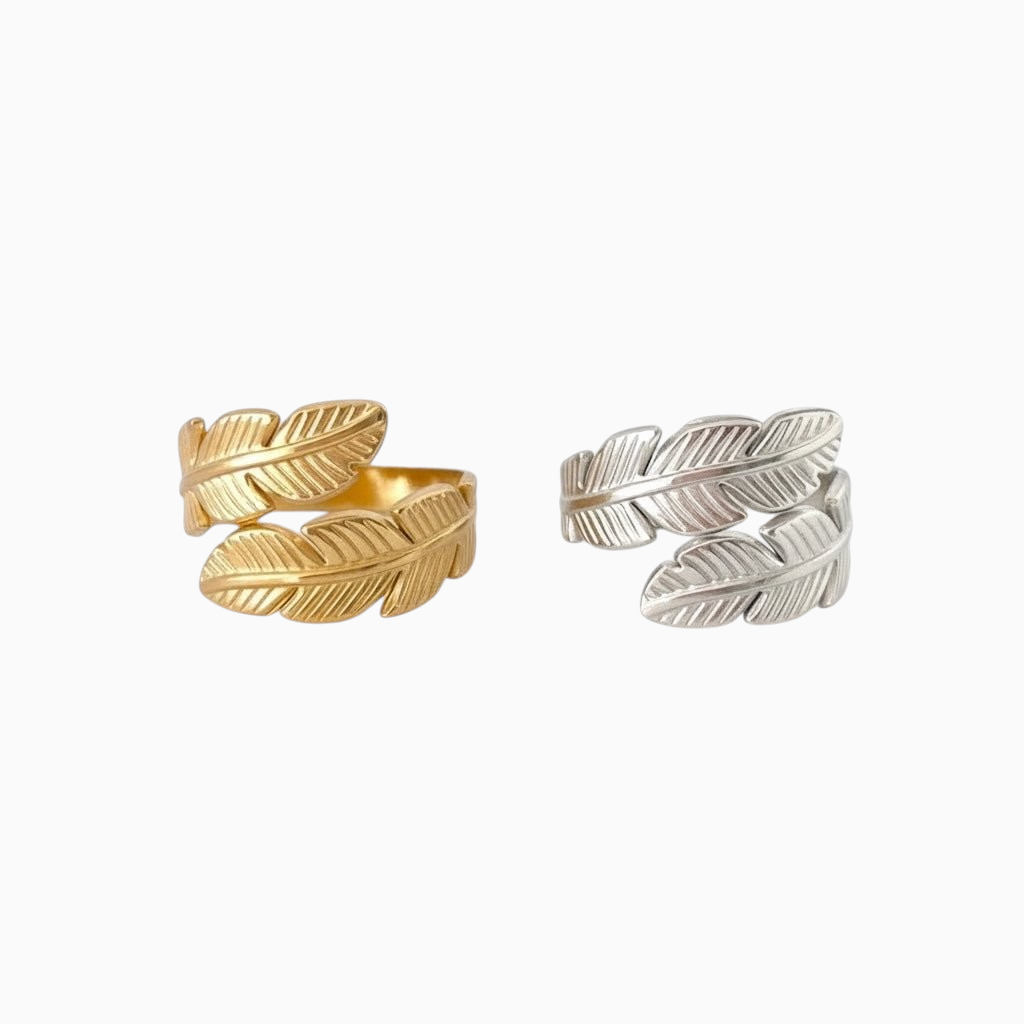 Anéis GRINE com design de folhas entrelaçadas em aço inoxidável, disponíveis em acabamento dourado e prateado.