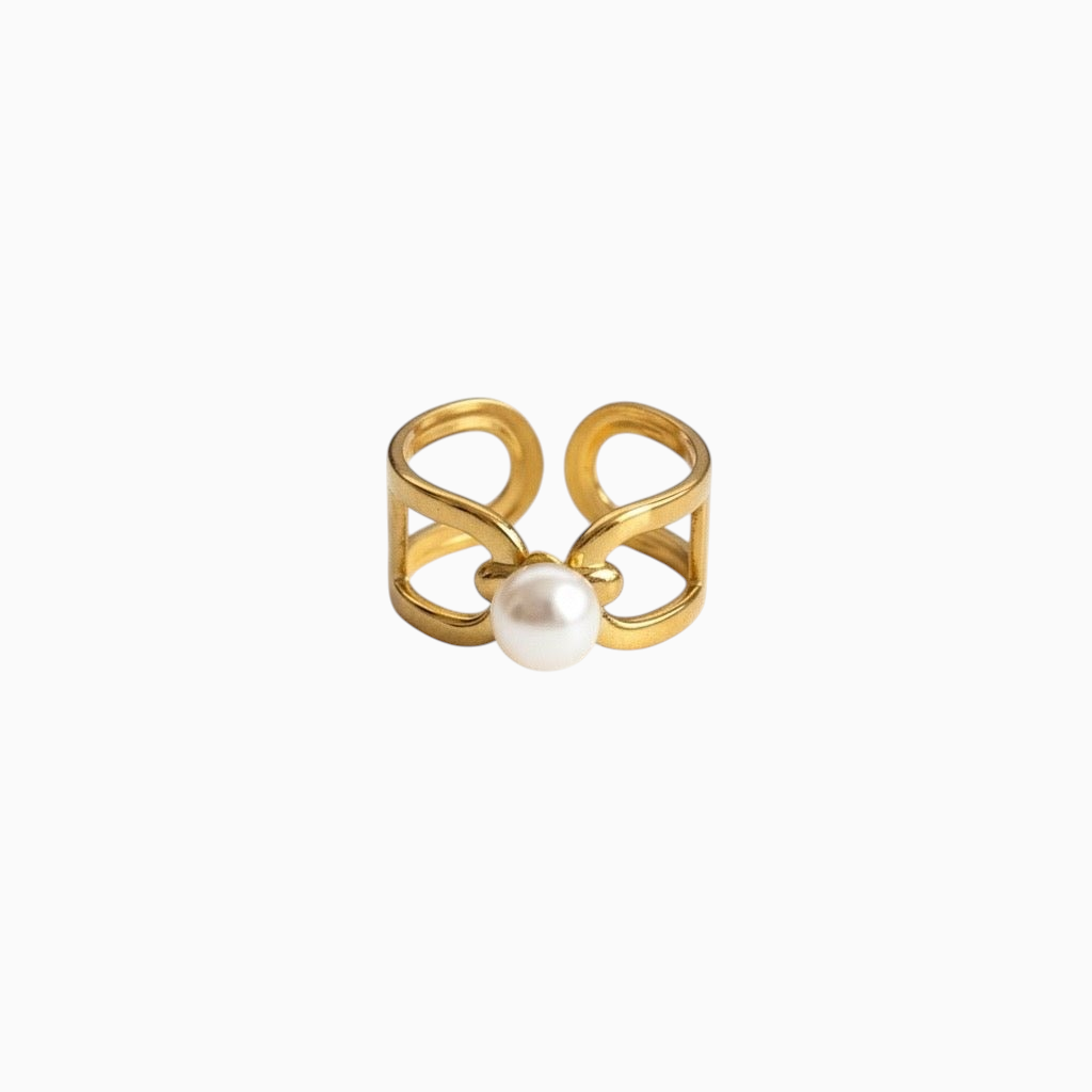 Anel largo GRINE em aço inoxidável dourado com design estruturado e pérola central ajustável.