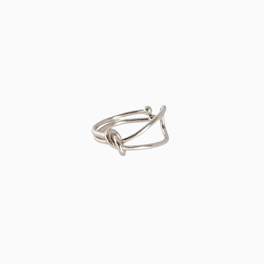 Anel GRINE com design de nó minimalista em acabamento prateado, elegante e sofisticado sobre fundo branco.