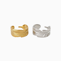 Anéis GRINE em forma de pena, feitos em aço inoxidável com acabamentos dourado e prateado, design ajustável.