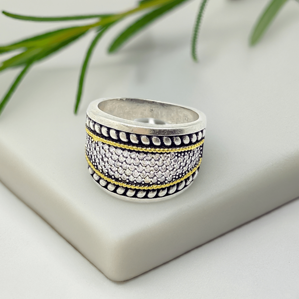 Anel GRINE Glamour Real com banho de prata, detalhes dourados e pedras brilhantes em design luxuoso