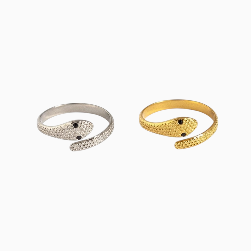 Anéis GRINE em formato de serpente envolvente, um prateado e um dourado com detalhes texturizados e olhos escuros.