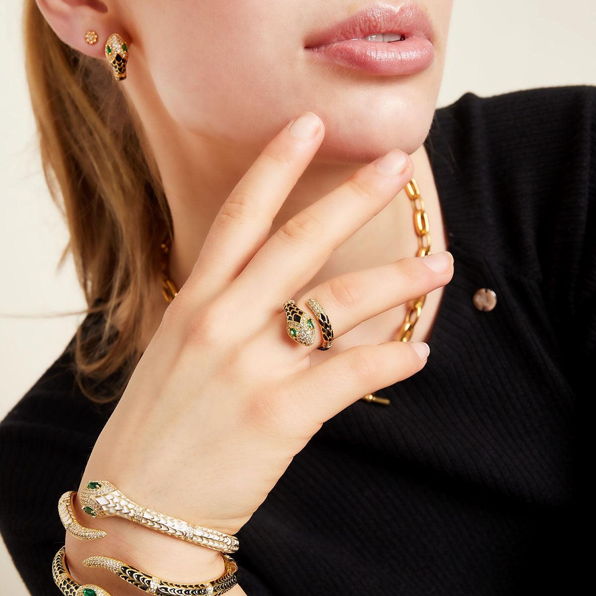 Anel GRINE em forma de serpente de cobre com enamel rosa, zircónias brilhantes e olhos verdes no dedo de uma modelo.
