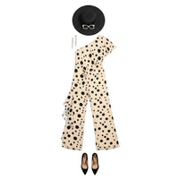 GRINE beige one-shoulder jumpsuit with black polka dots, elastic waist, and wide legs. Model wears a black hat and heels.