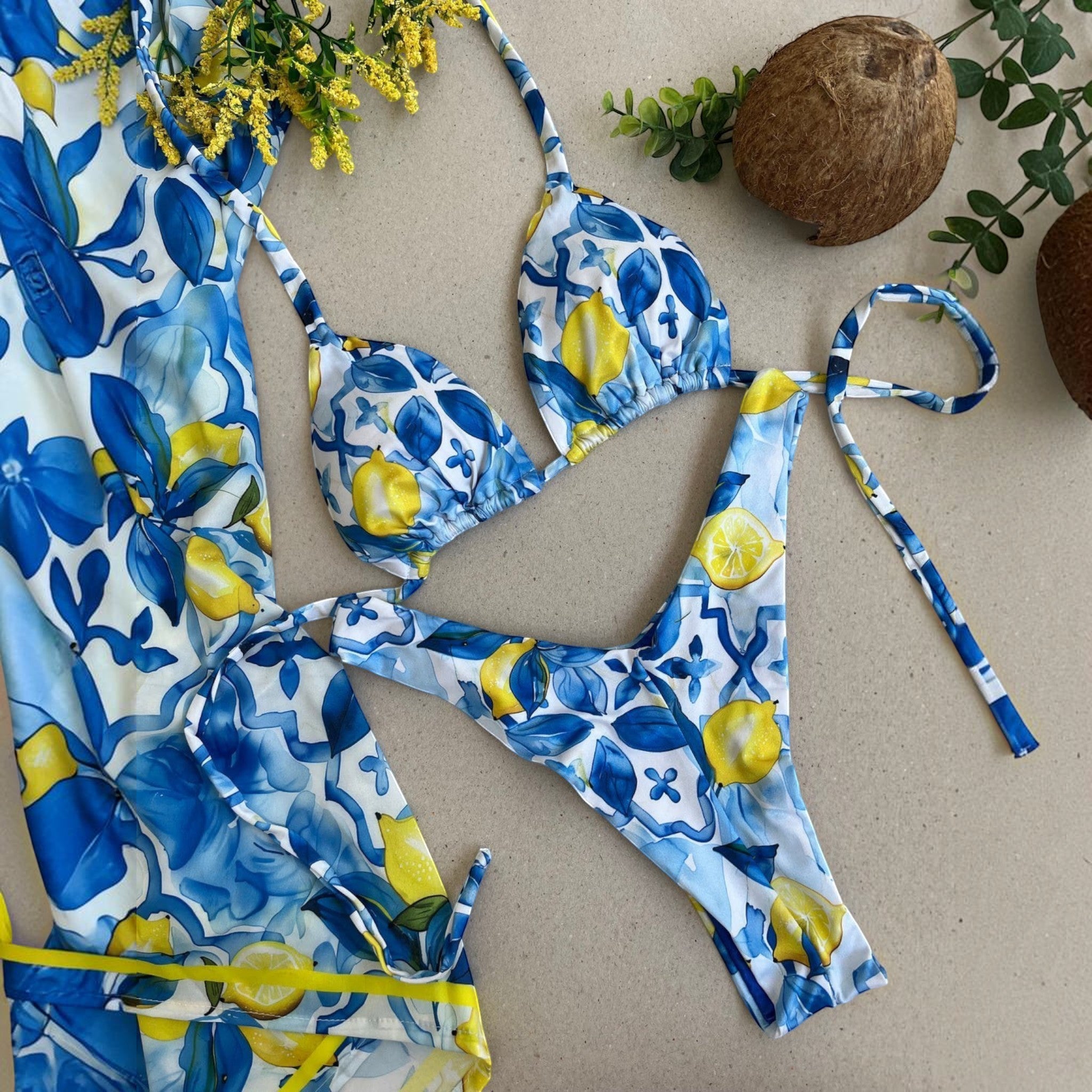 Biquíni GRINE modelo cortininha e asa delta com estampa de limões amarelos sobre fundo azul e branco