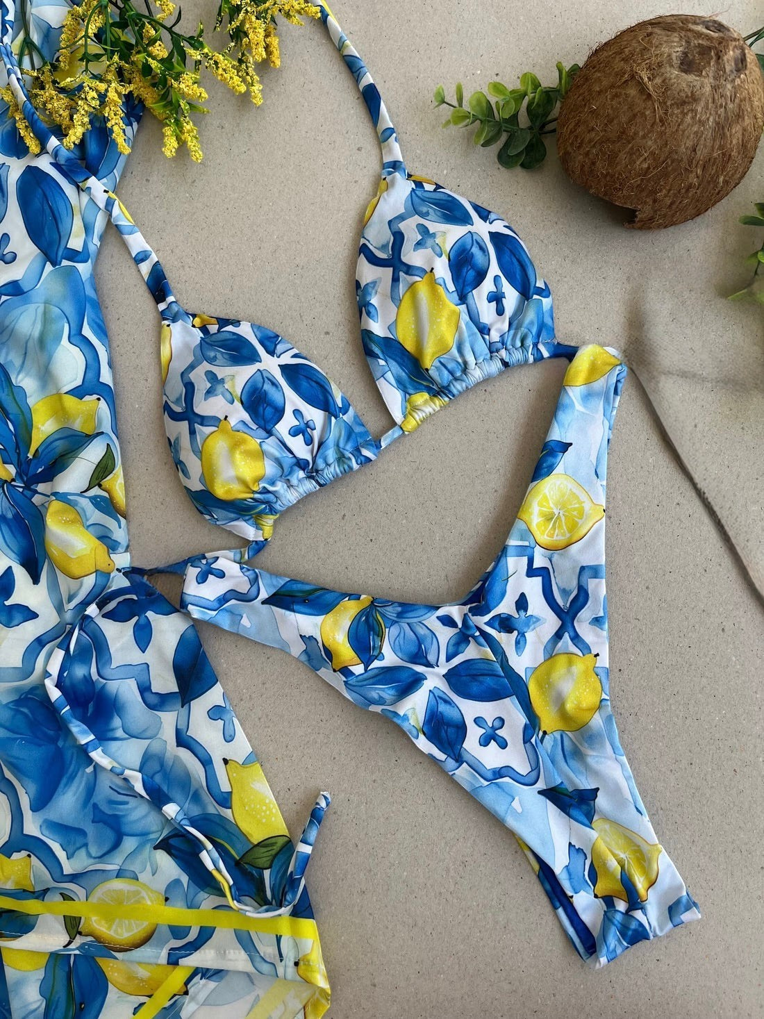Biquíni GRINE modelo cortininha e asa delta com estampa de limões amarelos sobre fundo azul e branco mediterrânico