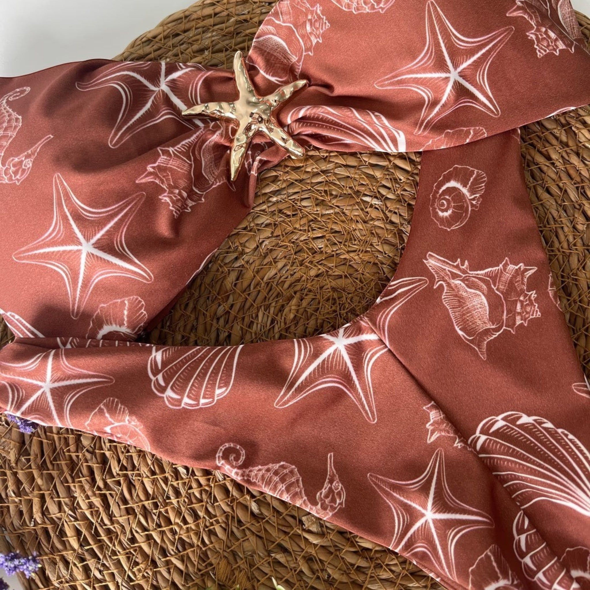 Biquíni GRINE Sardenha tomara que caia castanho com estampa de conchas e estrelas-do-mar e detalhe de estrela dourada.