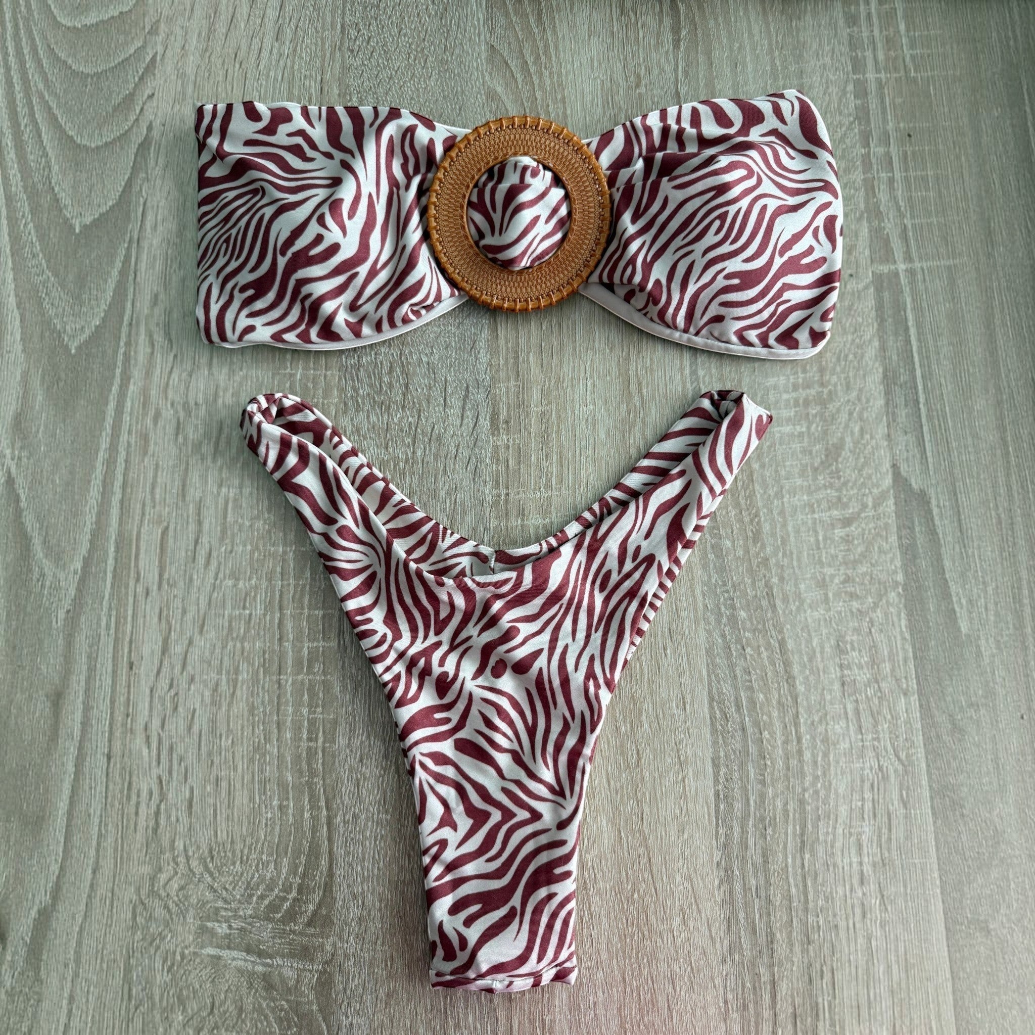 Biquíni GRINE Savana castanho com padrão animal print, top cai-cai com detalhe em madeira e cueca asa delta.