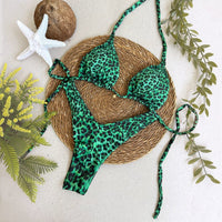 Biquíni GRINE cortininha e asa delta com estampa animal print verde esmeralda sobre base de palha com estrela do mar.