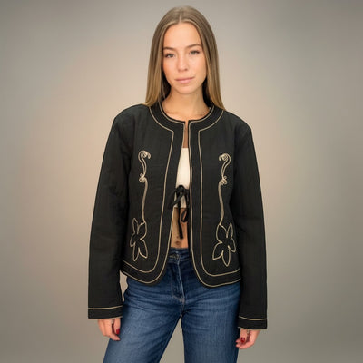GRINE black quilted cropped jacket with embroidered trim and tie front closure. Features a floral motif.