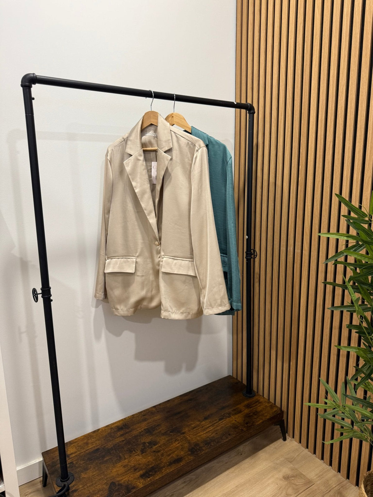 Blazer oversize acetinado GRINE bege com corte fluido, um botão e bolsos frontais, pendurado num cabide