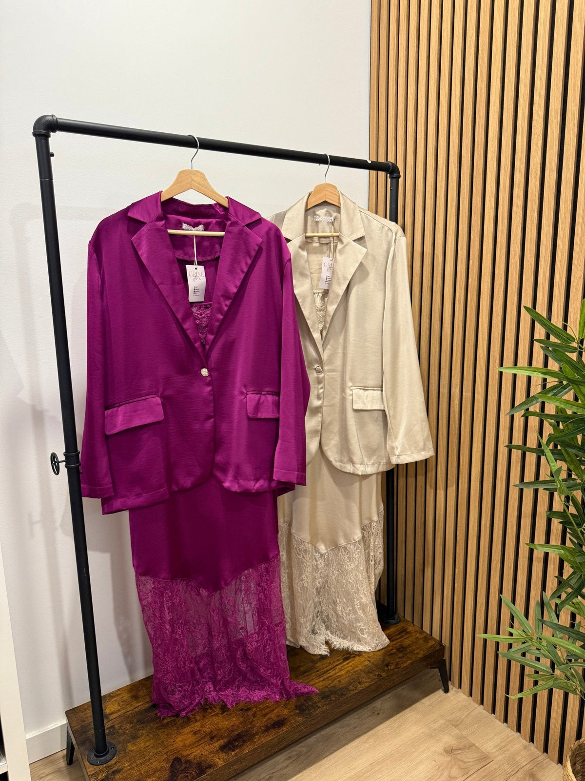 Blazer oversize acetinado GRINE em tons de roxo e bege, fluido com um botão e bolsos, exposto em cabides.