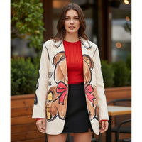 Blazer oversized bege GRINE com estampa de urso central, usado por modelo com camisola vermelha e saia preta.
