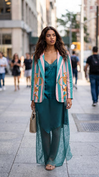 Modelo veste blazer GRINE oversized de camurça sintética com riscas pastel e leopardos nas lapelas em rua urbana
