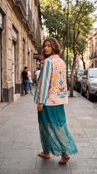 Modelo veste blazer GRINE oversized em camurça sintética com riscas pastel e ilustração de leopardo e borboleta