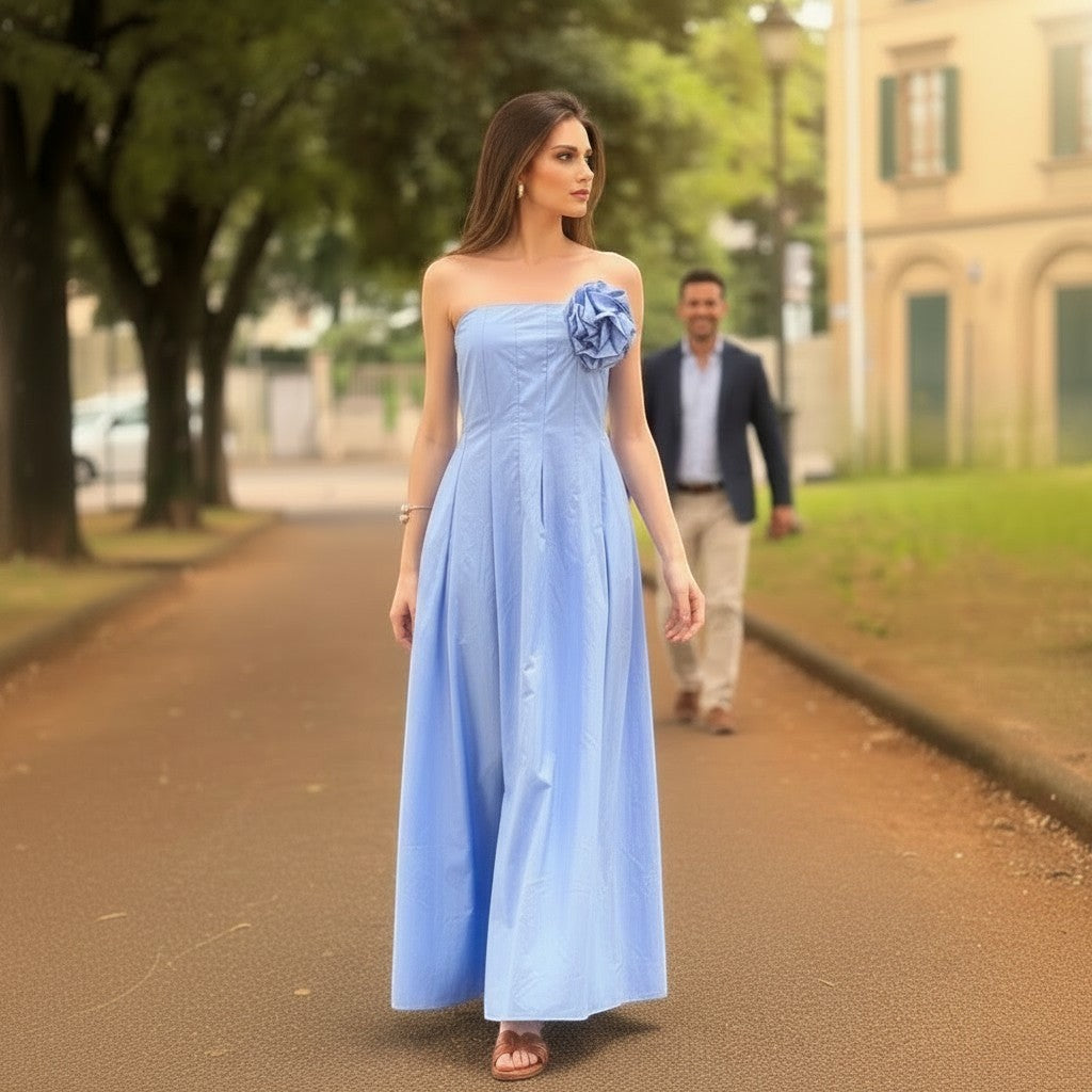GRINE light blue cotton strapless maxi dress with a removable flower detail and elasticated bust. Model wears sunglasses and sandals.