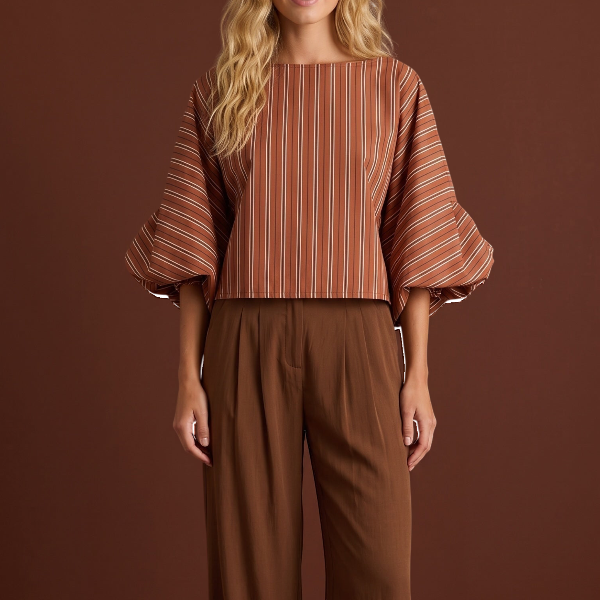 Modelo veste blusa GRINE curta listrada em tons terrosos com mangas bufantes volumosas e punhos franzidos