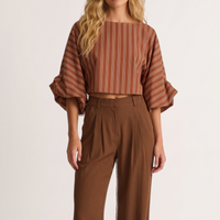 Modelo veste blusa curta GRINE listrada em tons terrosos com mangas bufantes volumosas e punhos franzidos