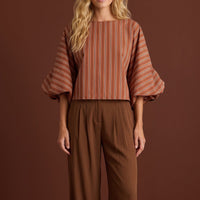 Modelo veste blusa GRINE curta listrada em tons terrosos com mangas bufantes volumosas e punhos franzidos