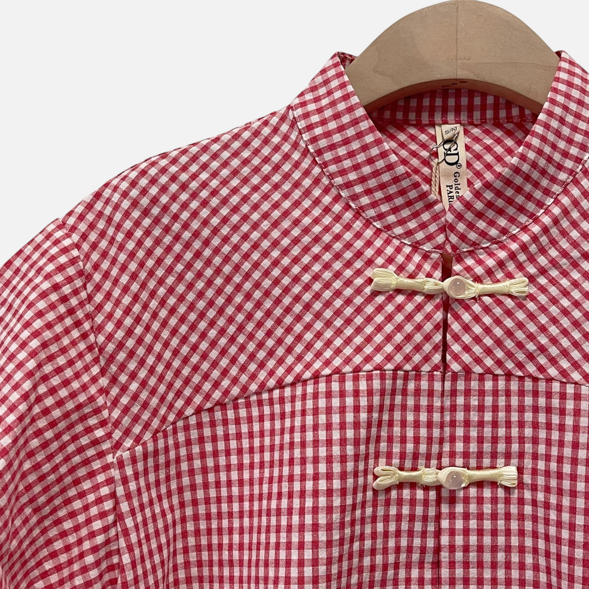 Blusa GRINE em algodão com padrão xadrez Vichy vermelho, gola mandarim e botões de nó oriental.