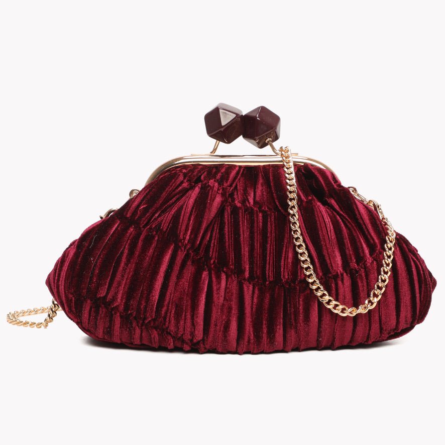 Bolsa de festa GRINE em veludo bordeaux com textura plissada, fecho de molas decorativo e alça de corrente dourada.