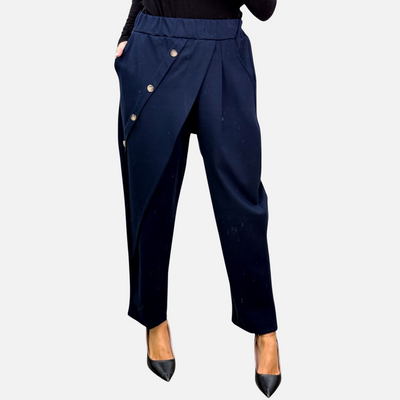 Calça envelope GRINE azul marinho com fecho diagonal, botões prateados e corte fluido de cintura alta.