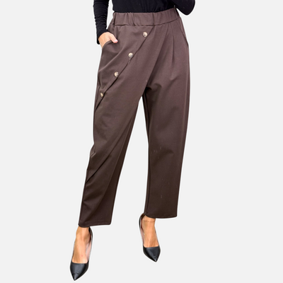 Calça envelope castanha GRINE com fecho diagonal, botões prateados e corte fluido de cintura alta.