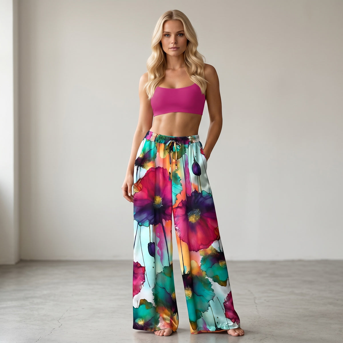 Calças acetinadas GRINE com padrão floral vibrante em rosa, verde e roxo, corte direito e cintura elástica.