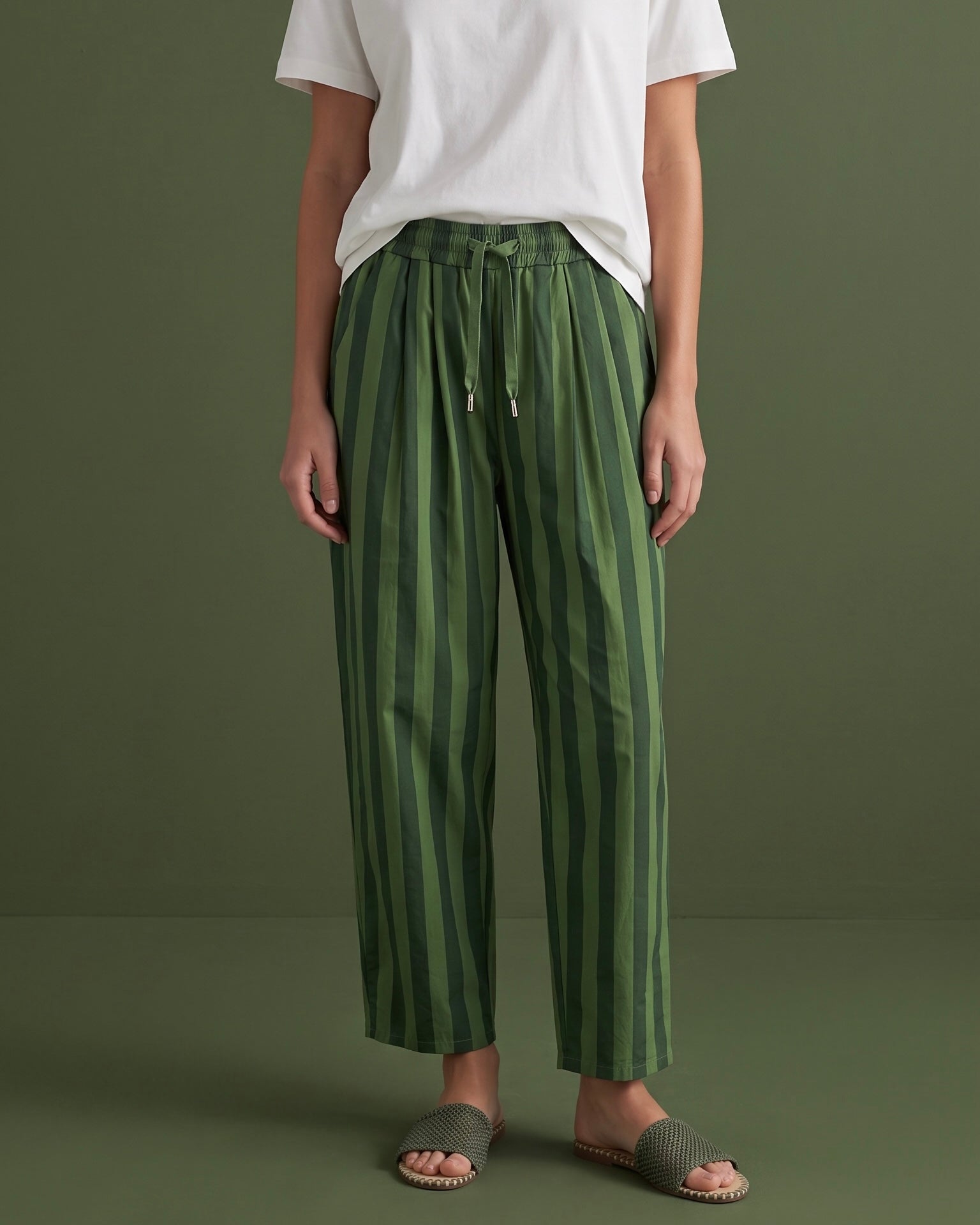 Calças baggy GRINE de algodão com riscas verticais verdes, cintura subida com cordão e corte largo e fluido.