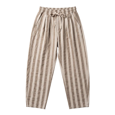 Calças baggy GRINE de algodão com riscas verticais bege e brancas, cintura subida com pregas e cordão ajustável.