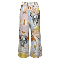 Calças Carmen GRINE de perna larga com estampado artístico tropical, caveiras florais e padrão abstrato em tons suaves. Cintura elástica com cordão.