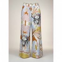 Calças Carmen GRINE de perna larga com estampado artístico tropical, caveiras florais e cintura elástica. Tons suaves e quentes.