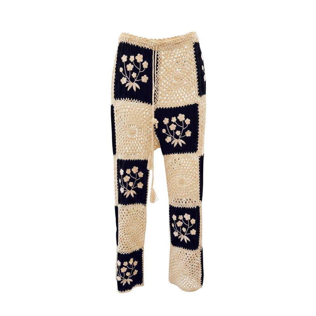 Calças GRINE pretas em croché com padrão de quadrados e flores bordadas, cintura ajustável com cordão.