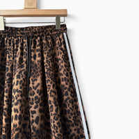 Calças jogger GRINE oversized com padrão animal print, riscas laterais brancas e cintura elástica com cordão preto.