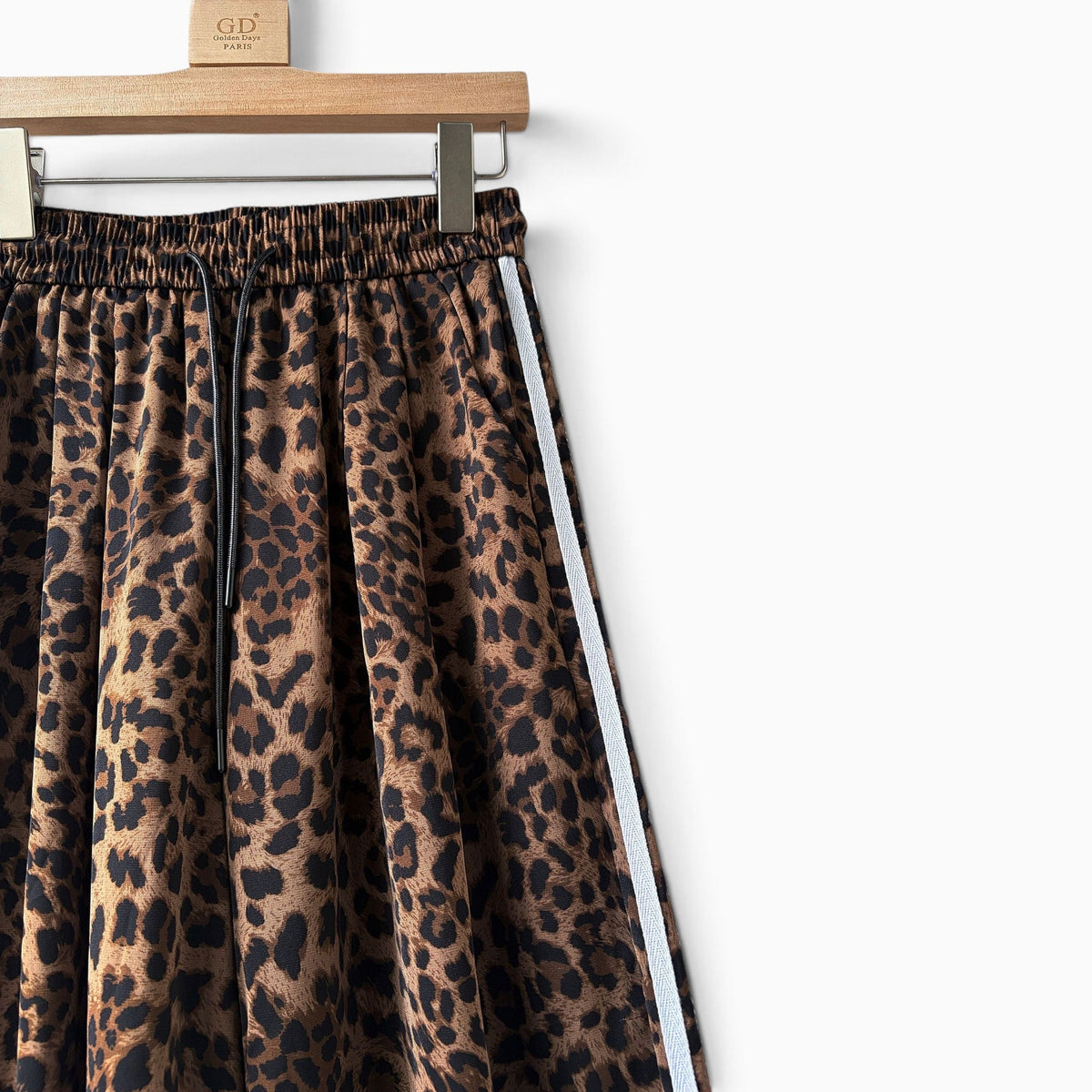 Calças jogger GRINE oversized com padrão animal print, riscas laterais brancas e cintura elástica com cordão preto.