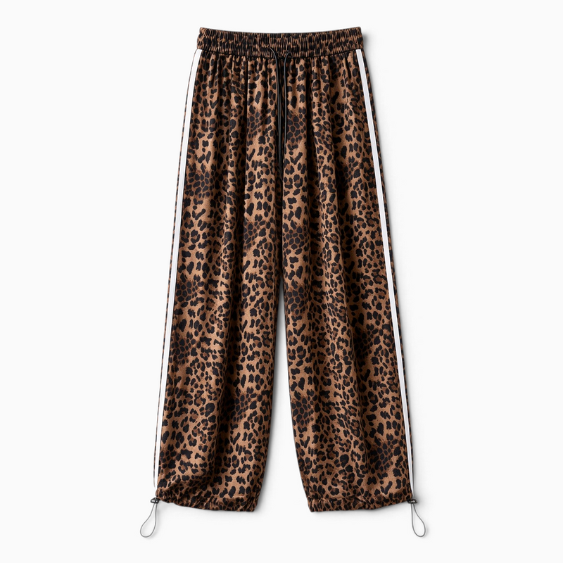 Calças jogger GRINE oversized com padrão animal print, riscas laterais brancas e bainhas ajustáveis com cordão.