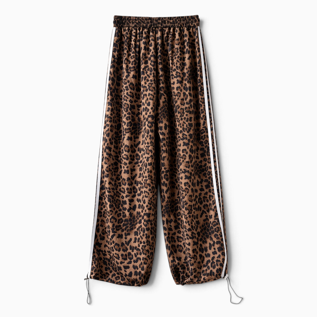 Calças jogger GRINE oversized com padrão animal print, riscas laterais brancas e bainhas ajustáveis.