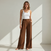 Modelo veste calças pantalona castanhas fluidas da GRINE com top branco, destacando o corte largo e elegante.