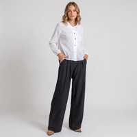 Modelo veste calças pantalona pretas fluidas da GRINE com camisa branca, destacando o corte largo e elegante.