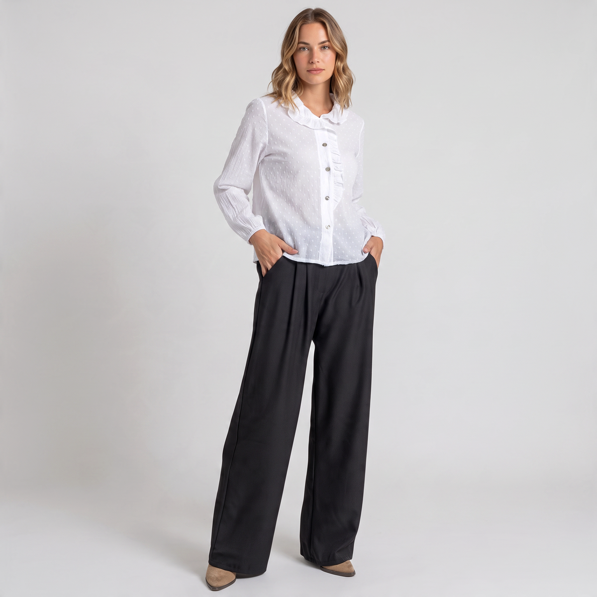 Modelo veste calças pantalona pretas fluidas da GRINE com camisa branca, destacando o corte largo e elegante.