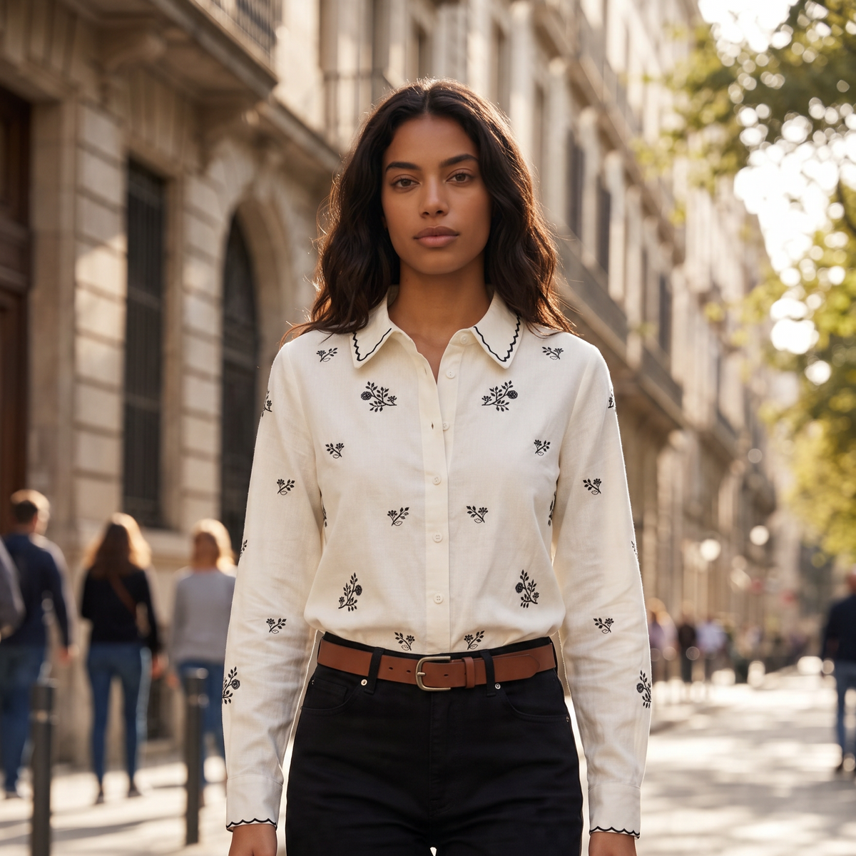 Mulher a usar camisa branca GRINE em algodão com bordados pretos florais e gola clássica em ambiente urbano