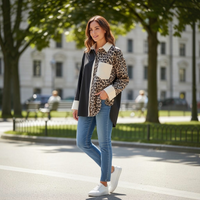 Mulher usa camisa larga GRINE com padrão animal print e painel preto, combinada com calças de ganga e ténis brancos.