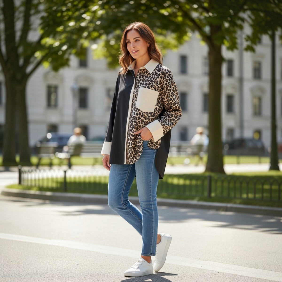Mulher usa camisa larga GRINE com padrão animal print e painel preto, combinada com calças de ganga e ténis brancos.