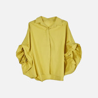 Camisa GRINE oversized amarela com mangas morcego volumosas, punhos drapeados e carcela frontal oculta em tecido fluido
