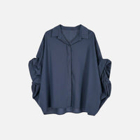 Camisa GRINE oversized azul marinho com corte fluido, mangas morcego volumosas e punho drapeado em tecido leve.
