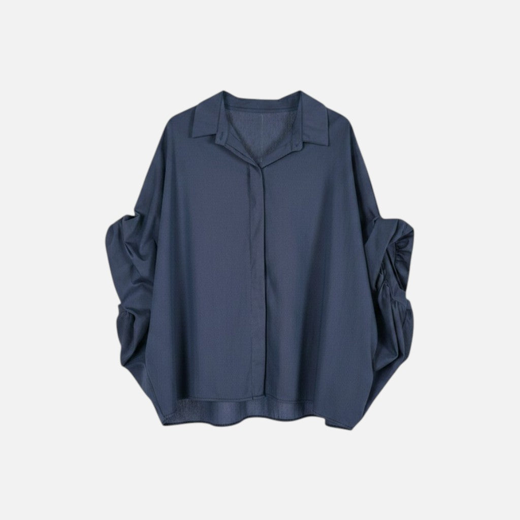Camisa GRINE oversized azul marinho com corte fluido, mangas morcego volumosas e punho drapeado em tecido leve.