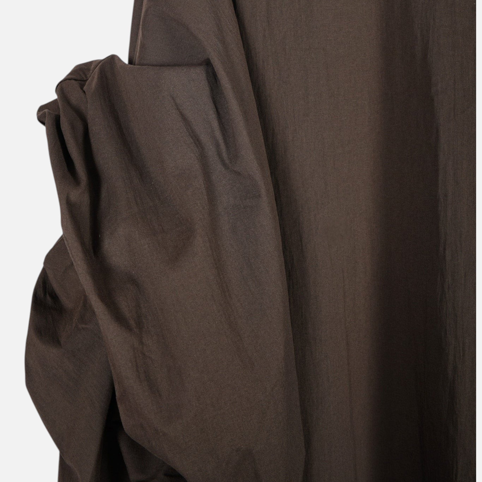 Detalhe da manga morcego drapeada de camisa oversized castanha GRINE em tecido fluido de algodão e nailon